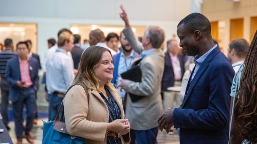 Attendees at the 2023 Southeastern Entrepreneurship Through Acquisition Conference speak in the Kirby Winter Garden of The Fuqua School of Business