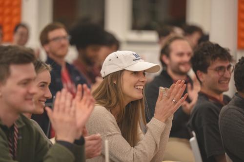 Elle Smyth '20 wearing a baseball cap and clapping at Y Combinator